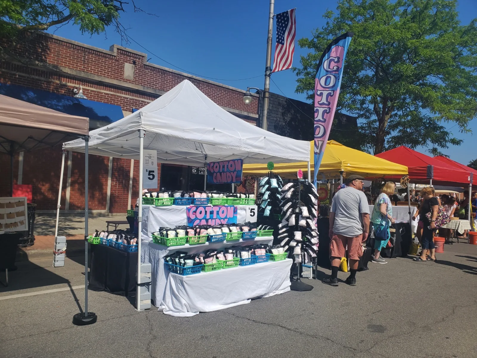 Tiered Falanga's display loaded with bagged cotton candy at a summer street festival
