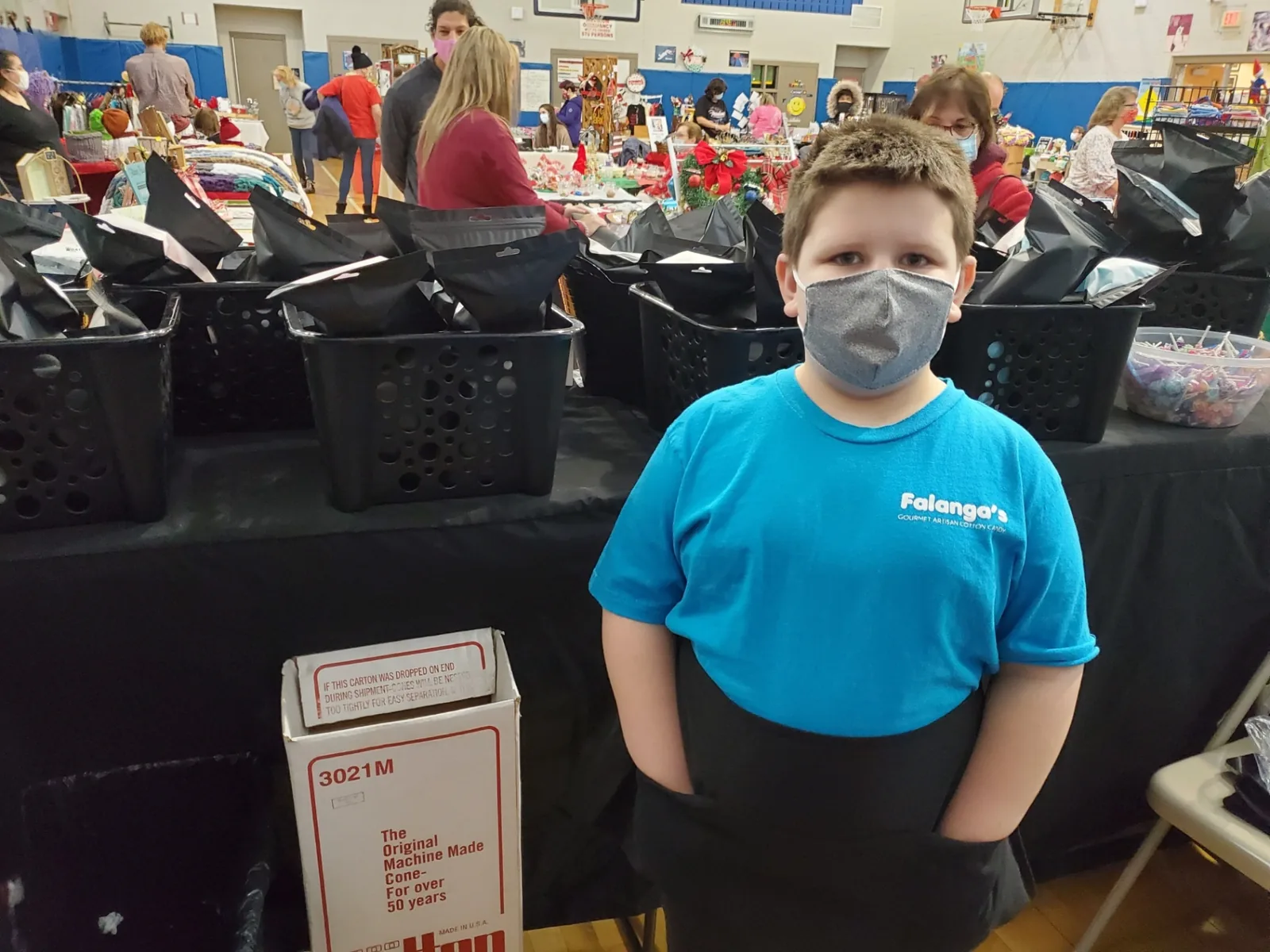 Young Falanga's team member at a holiday craft fair with bagged cotton candy