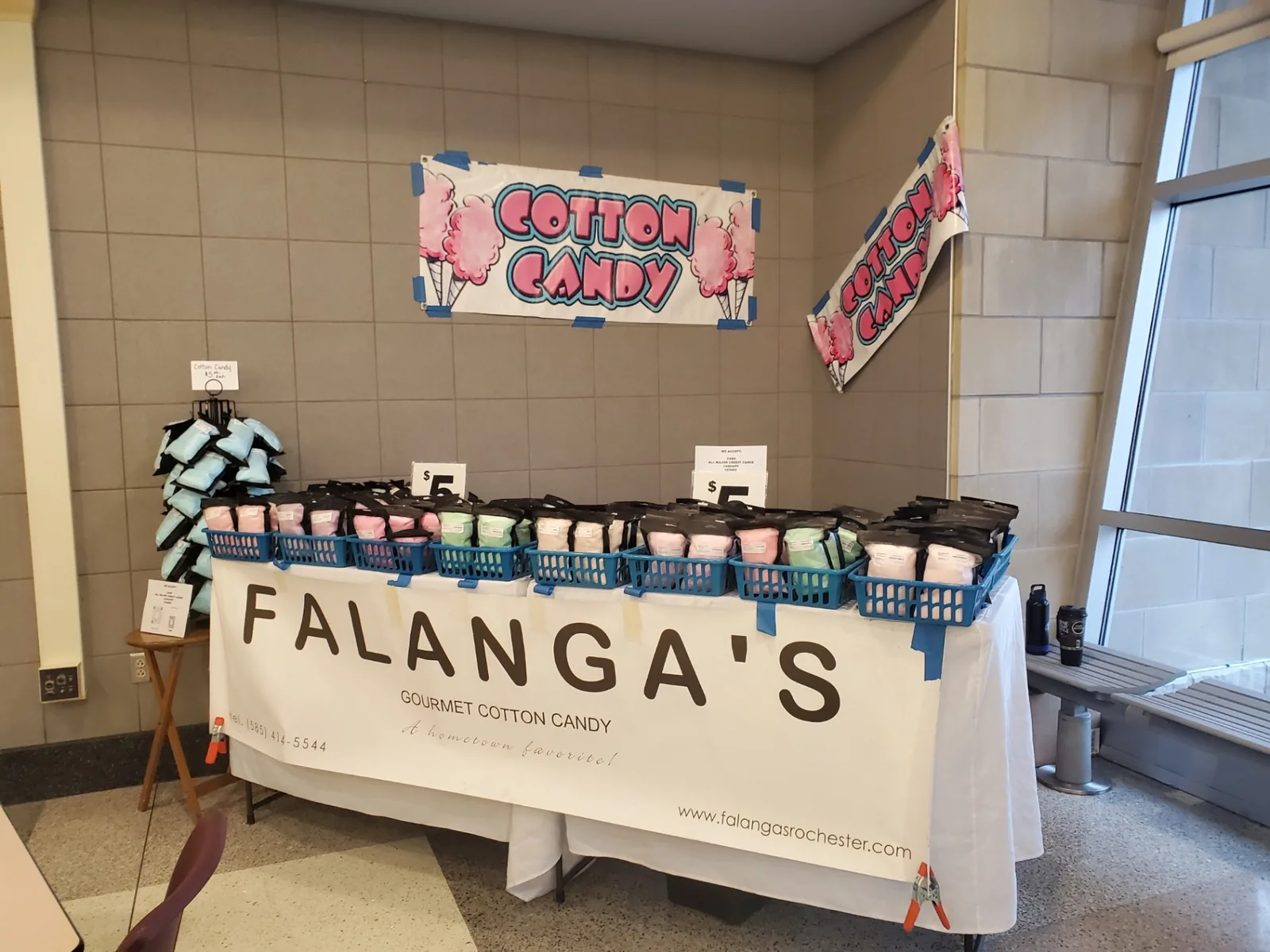 Falanga's banner table lined with baskets of cotton candy at a school event