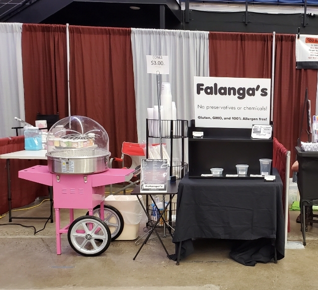 Falanga's cotton candy cart and signage at an indoor vendor booth