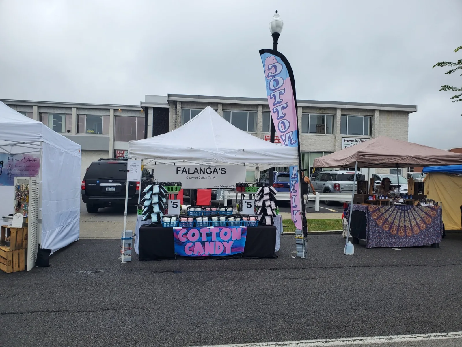 Falanga's tent with cotton candy feather flag at a Rochester street fair