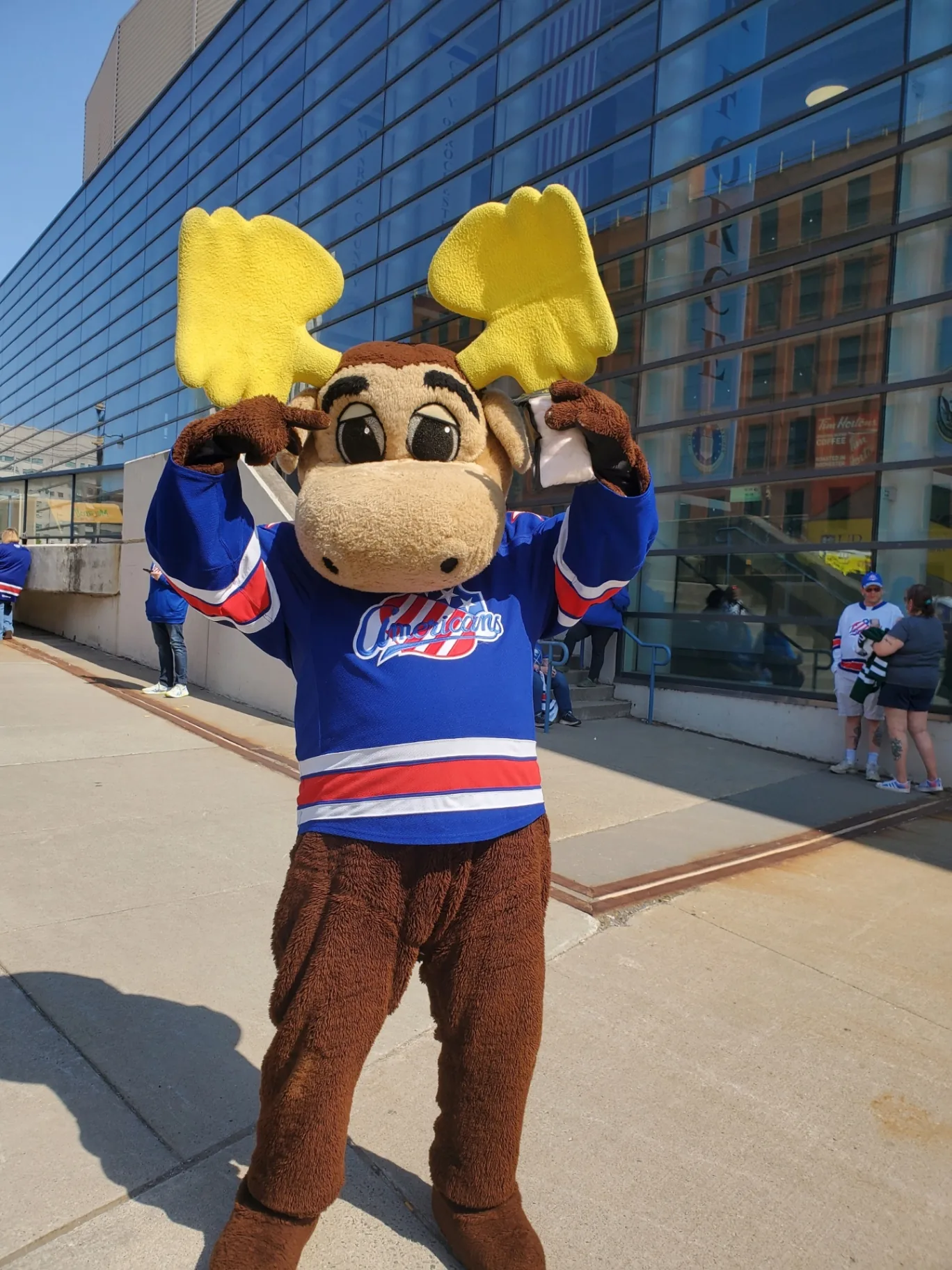 Rochester Amerks moose mascot holding bags of Falanga's cotton candy downtown