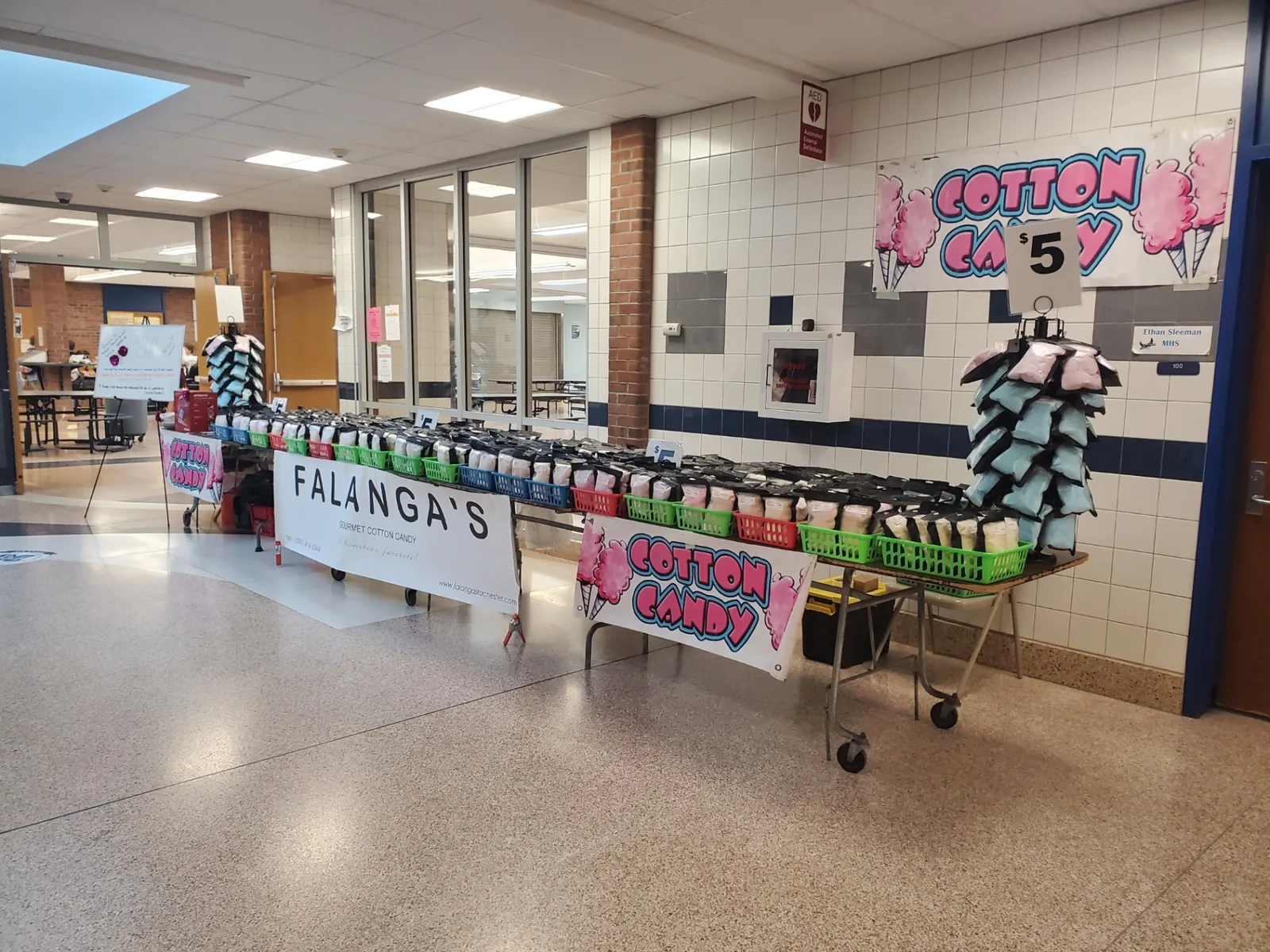 Long table of Falanga's cotton candy bags set up in a school hallway fundraiser